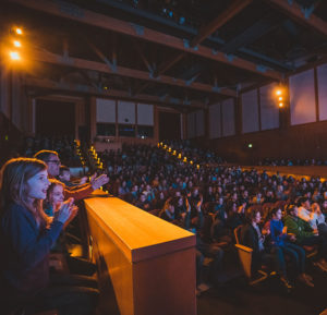 Students and parents enjoying a performance in the theatre.