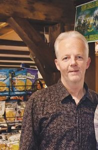 Photo of Jeff Clarke in a brown patterned shirt standing in his store Edelweiss