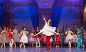 Vermont Youth Dancers performance - elaborate ballet costumes and dancer leaping in white with blue violet backdrop